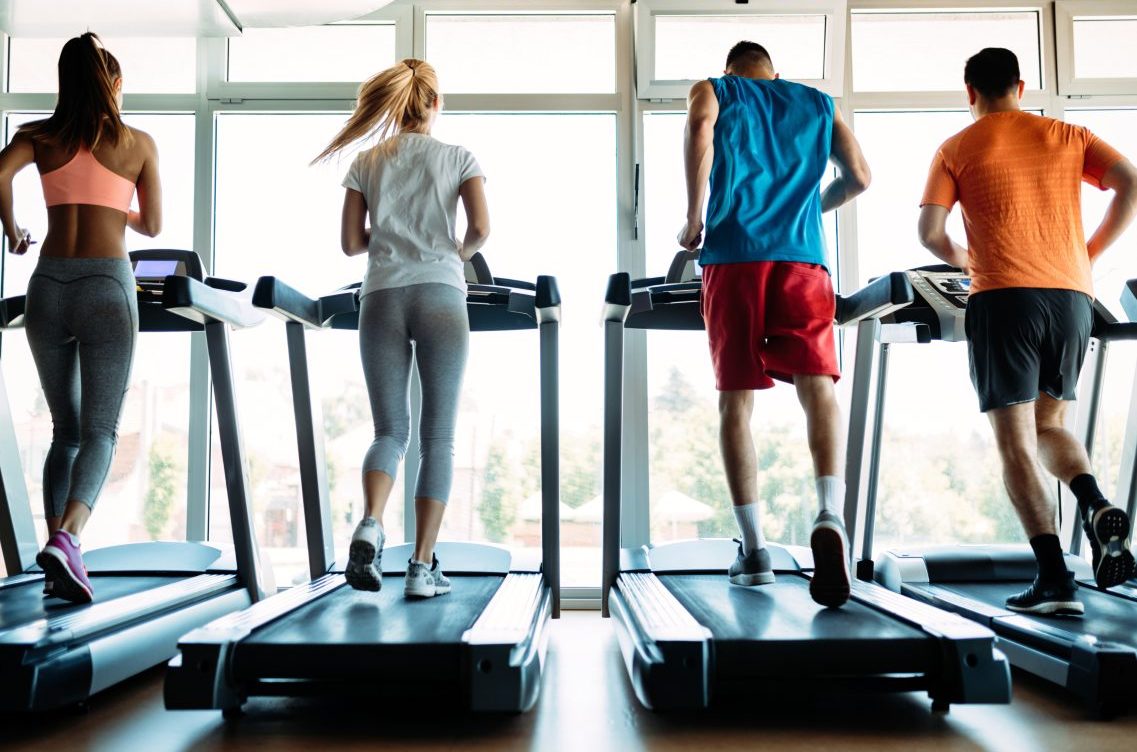 A group of people running on treadmills.