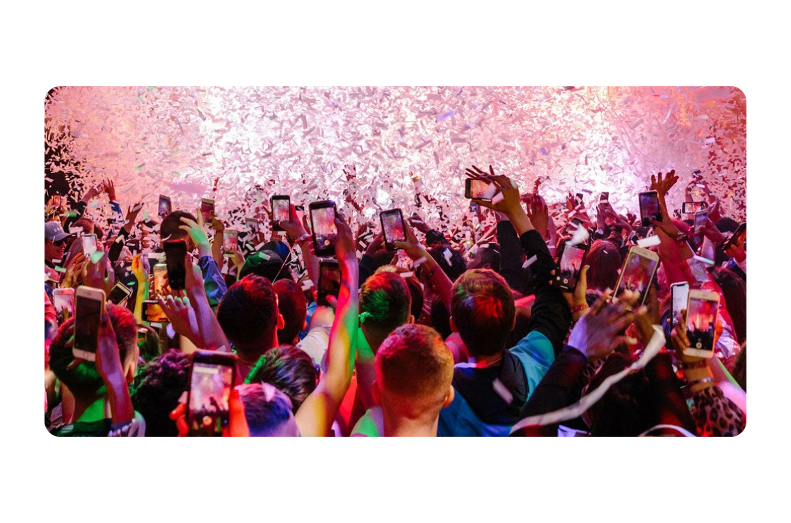 Crowd image with crowd using phones to capture scenes of confetti at Parklife festival