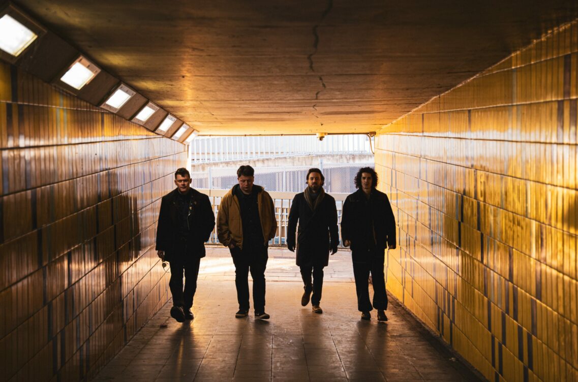 Image of band members walking through a tunnel