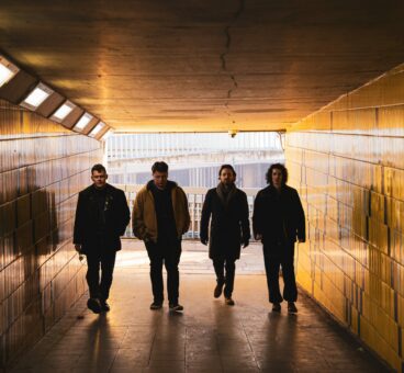 Image of band members walking through a tunnel